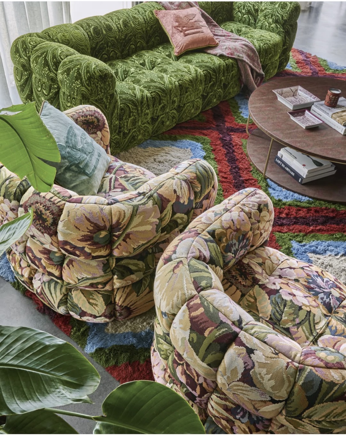 Zielona welurowa sofa i fotele w kwiatowym gobelinie na wielobarwnym dywanie