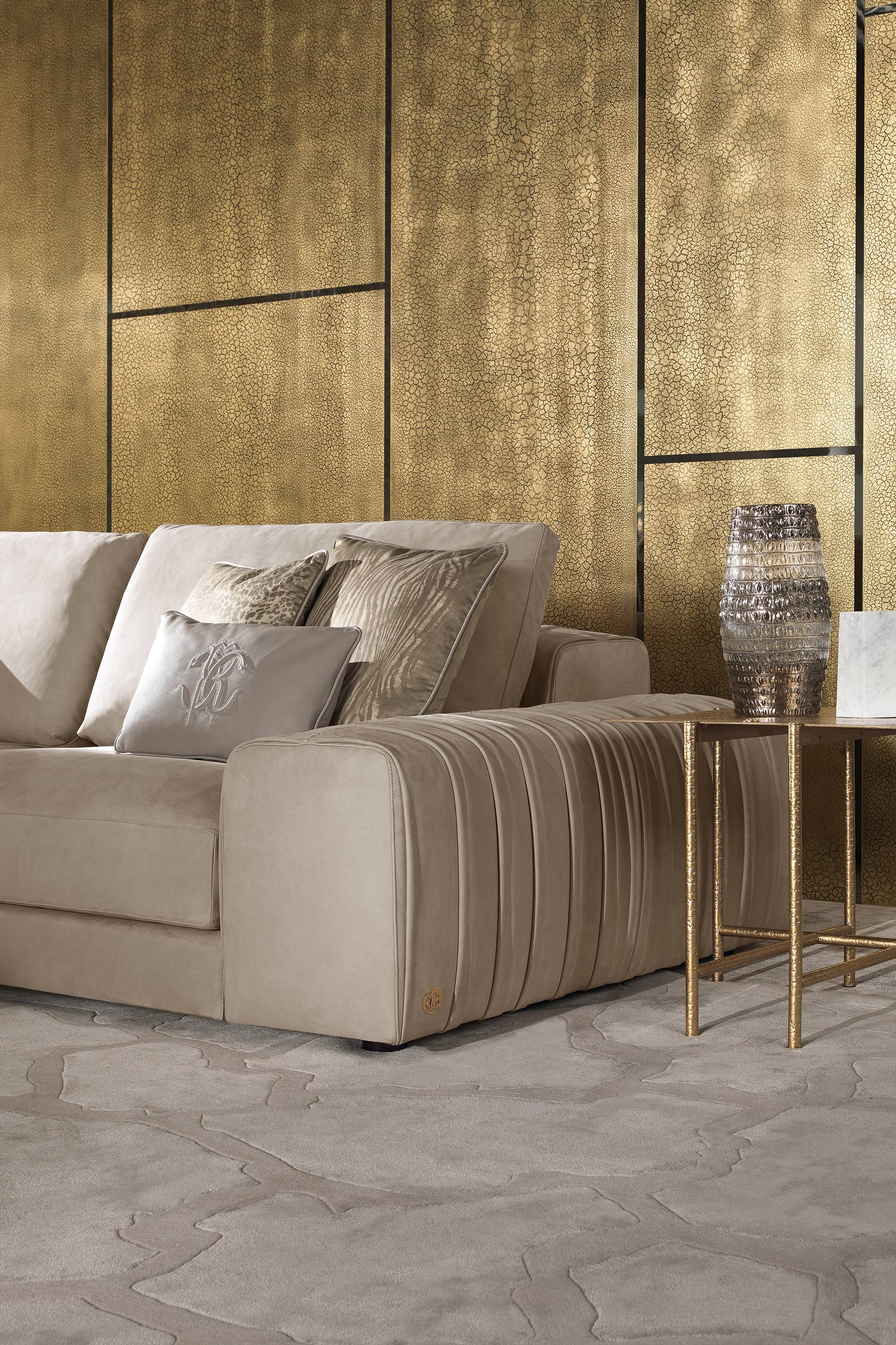 Złote spękane panele, sofa w skórze z przeszyciami
