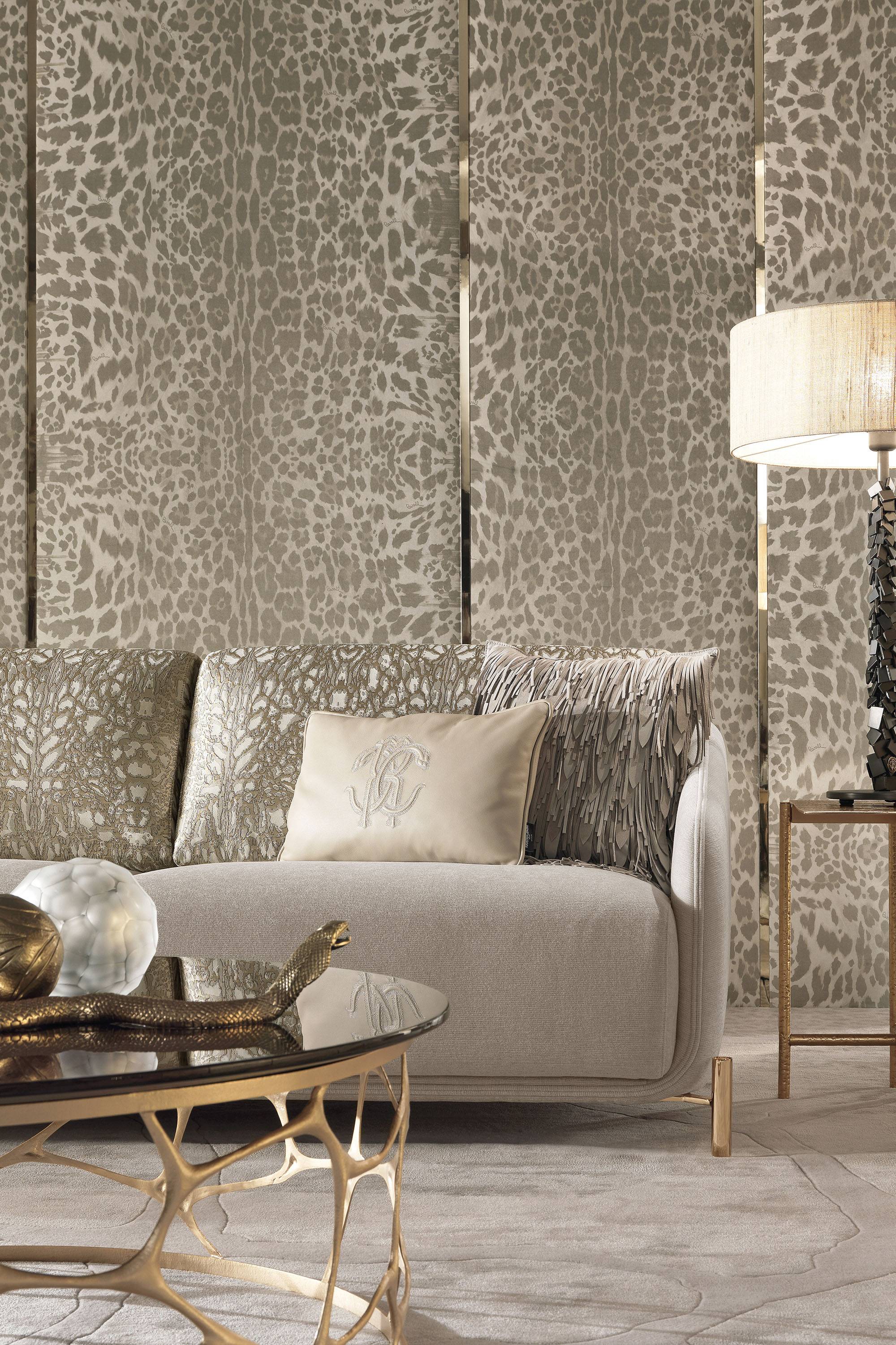 Panele w cętki leoparda ze złotymi listwami, sofa i poduszka z monogramem